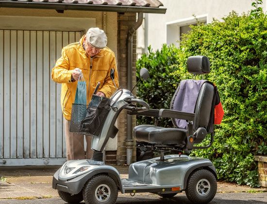Senior man with heavy duty mobility scooter outdoors